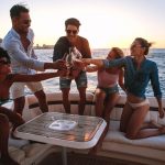 Diverse-friends-toasting-drinks-in-boat-party